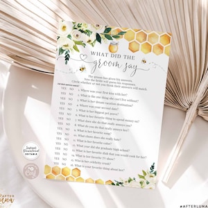 Puede incluir: Una tarjeta de juego imprimible con un fondo de panal de abeja amarillo y flores blancas. La tarjeta tiene el texto "What did the groom say?" y una lista de preguntas para un juego de despedida de soltera.