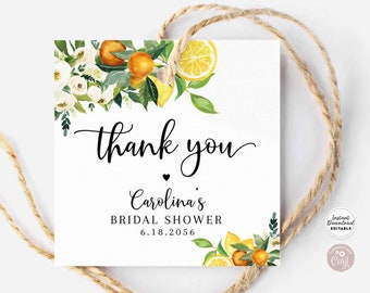 Puede incluir: Una etiqueta de agradecimiento blanca con un corazón negro y el texto "gracias" en cursiva. La etiqueta está decorada con una ilustración de acuarela de limones, naranjas y flores blancas. El texto "Carolina's Bridal Shower 6.18.2056" está impreso debajo del corazón.