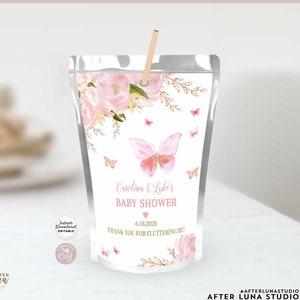 May include: Pink and gold butterfly baby shower juice pouch favor with the text "Carolina & Luke's Baby Shower" and "Thank you for fluttering by!" with the date 6.18.2028.