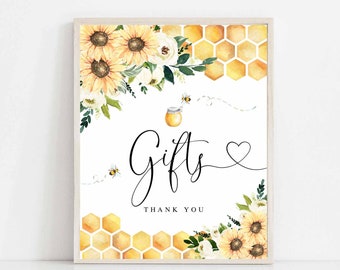 May include: A printable sign with a white background, featuring a honey pot, bees, sunflowers, and honeycomb. The sign says "Gifts" with a heart and "Thank You".