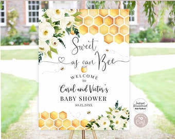 May include: A white welcome sign with a honeycomb pattern and floral accents. The text reads "Sweet as can Bee" and "Welcome to Carol and Victor's Baby Shower 10.15.20XX".