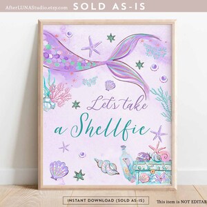 Puede incluir: Una cola de sirena morada y turquesa con un diseño de concha y estrella de mar. El texto "Let's take a Shellfie" está escrito en una fuente caprichosa. La imagen es una descarga digital imprimible.