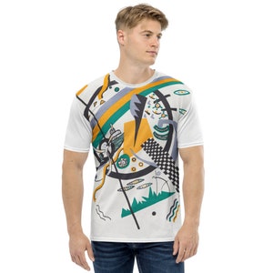 May include: A white t-shirt with a colourful abstract design featuring geometric shapes, lines, and a green and yellow colour scheme.
