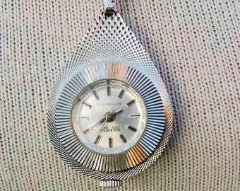 Vintage zilver gekleurde hanger horloge op lange zilveren gekleurde ketting. Niet werkende conditie.