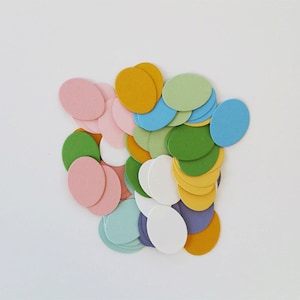 May include: A collection of colorful paper circles in various shades of pink, green, blue, yellow, and white. The circles are arranged in a random pattern, creating a visually appealing and festive design.