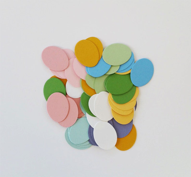 May include: A collection of colorful paper circles in various shades of pink, green, blue, yellow, and white. The circles are arranged in a random pattern, creating a visually appealing and festive design.