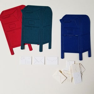 May include: Three paper mailboxes, one red, one blue, and one green, with white paper envelopes and postcards scattered around them.