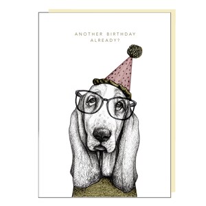 May include: A black and white illustration of a basset hound wearing a pink party hat with a black pom-pom and black framed glasses. The text "Another birthday already?" is above the dog.