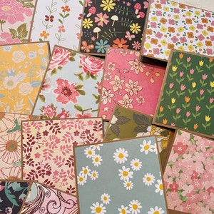 May include: A collection of 12 different patterned paper cards with floral designs. The cards are all square and have a brown border. The patterns include daisies, tulips, butterflies, and other floral motifs.