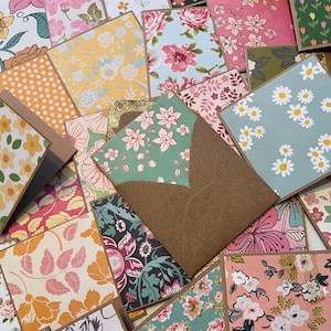 May include: A collection of small, square cards with various floral patterns. The cards are arranged in a random pattern and some are partially overlapping. The cards are all brown on the edges and have a rustic, vintage aesthetic.