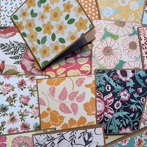 May include: A collection of patterned cards with floral designs. The cards are brown with a white background and feature various floral patterns in shades of pink, yellow, green, and blue.