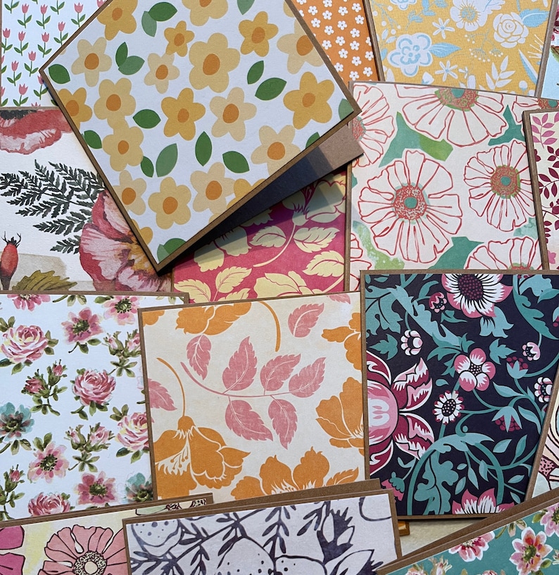 May include: A collection of patterned cards with floral designs. The cards are brown with a white background and feature various floral patterns in shades of pink, yellow, green, and blue.
