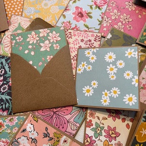 May include: A collection of handmade cards with various floral patterns. The cards are made with different colors and textures, including pink, blue, green, and yellow. The cards are perfect for sending a special message to someone you care about.