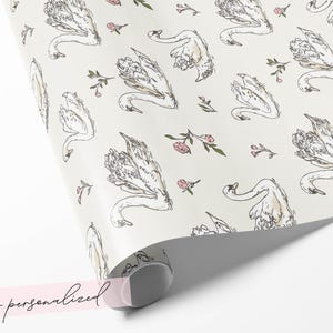 Non personalized swan wrapping paper roll mockup with ivory background blush floral sprigs and graceful bird illustration for romantic wedding gift packaging