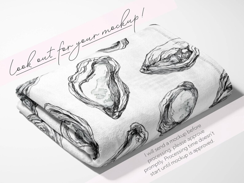 May include: Folded white blanket with a black and white oyster illustration. The blanket has a repeating pattern of oyster shells. The text "Look out for your mockup!" is written in cursive. The blanket is folded on a white surface.