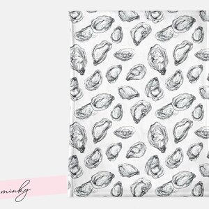 May include: A white blanket featuring a repeating pattern of grayscale oyster illustrations. The oysters are depicted in detail, in various sizes and orientations. The word "minky" is written in cursive on a pink banner.