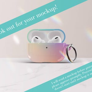 May include: A protective case for wireless earbuds featuring a smooth gradient transition from teal to pink and orange. The case is open, revealing white earbuds inside, and includes a silver metal ring attachment. Text reads: Look out for your mockup!