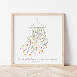 May include: A printable art print featuring a watercolour illustration of a floral bouquet hanging from a clothes hanger. The text "She is clothed with strength and dignity... Proverbs 31:25 NIV" is below the illustration.