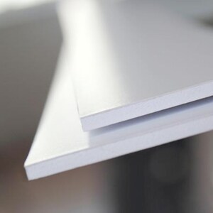 May include: Two white foam core boards stacked on top of each other. The top board is slightly angled to show the edge of the bottom board.