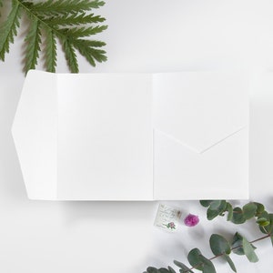 Pu&ograve; includere: Carta bianca piegata con una tasca sul davanti. La carta &egrave; vuota e pronta per essere scritta.