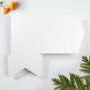Pu&ograve; includere: Un cartoncino bianco piegato con una linguetta appuntita. Il cartoncino &egrave; vuoto e pronto per essere scritto o decorato.