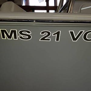 Könnte beinhalten: Ein graues Boot mit der Registrierungsnummer "MS 21 VC" an der Seite.