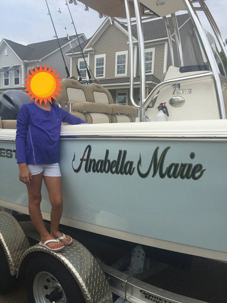 K&ouml;nnte beinhalten: Ein hellblaues Boot mit dem Namen "Anabella Marie" auf der Seite. Das Boot steht auf einem Anh&auml;nger mit einem schwarzen Reifen und einer silbernen Diamantplatte.