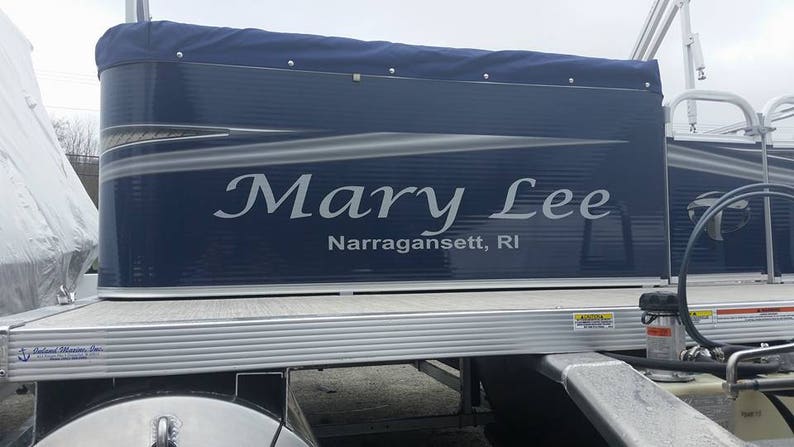 K&ouml;nnte beinhalten: Ein blaues und silbernes Pontonboot mit dem Namen "Mary Lee" und dem Ort "Narragansett, RI" auf der Seite.