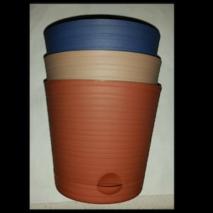 May include: Three plastic plant pots stacked on top of each other. The top pot is blue, the middle pot is beige, and the bottom pot is terracotta.