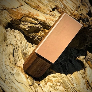 Puede incluir: Un acero de afilar rectangular con un mango de madera marrón y una superficie metálica marrón claro.