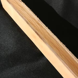 Puede incluir: Primer plano de un acero de afilar de madera marr&oacute;n claro con una superficie rugosa y texturizada.