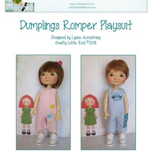 Puede incluir: Dos muñecas con monos. La muñeca de la izquierda lleva un mono rosa con flores bordadas. La muñeca de la derecha lleva un mono azul con un pequeño diseño de coche. Ambas muñecas tienen el pelo rojo y llevan zapatos blancos.