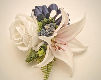 Conjunto de ramillete y boutonniere con rosas blancas, lirios y detalles en azul marino: elige tu cinta para flores de graduación.