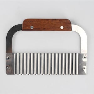 May include: A stainless steel wavy-edged cutter with a wooden handle. The cutter is designed to create decorative edges on vegetables and fruits.