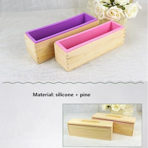 May include: Two wooden soap molds with removable silicone inserts. The molds are made of pine wood and have a natural finish. The silicone inserts are purple and pink.