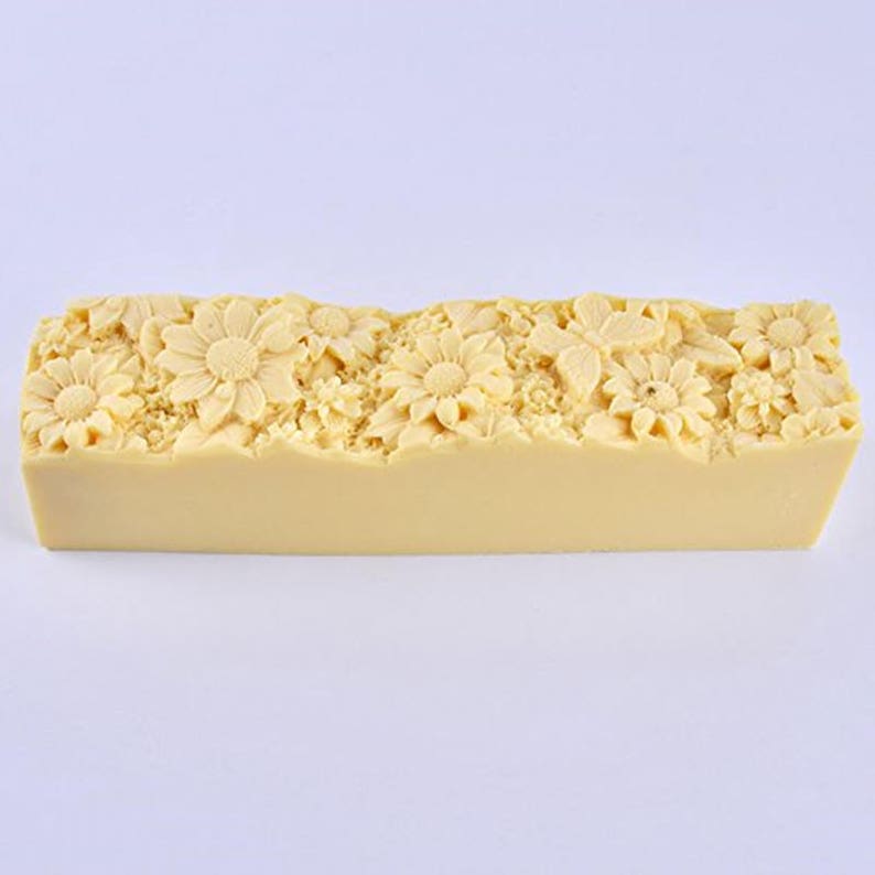 Pu&ograve; includere: Una saponetta rettangolare con un design floreale. Il sapone &egrave; di colore giallo pallido e presenta un design in rilievo di fiori e foglie.