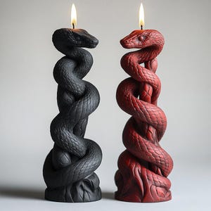 Puede incluir: Dos velas decorativas con forma de serpiente, una negra y otra roja, con llamas que arden en la parte superior.
