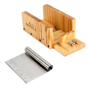 May include: A wooden soap cutting guide with a metal scraper. The guide has a label that says "Nicole" and has a series of slots for cutting soap bars into different sizes. The scraper has a ruler on one side.