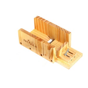 May include: Wooden soap cutting guide with metal pins and the text "NICOLE" printed on the side.