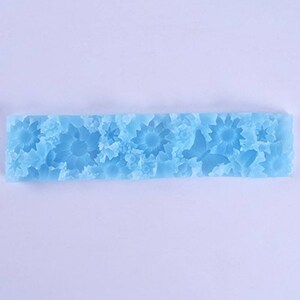 Pu&ograve; includere: Uno stampo in silicone blu chiaro con un design floreale. Lo stampo presenta un motivo ripetitivo di fiori stilizzati.