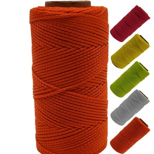 May include: A spool of bright orange string, with spools of red, yellow, green, gray, and orange string in the background.