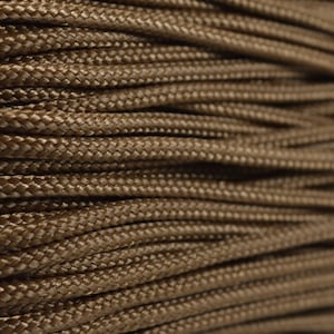 May include: Close-up of a spool of brown paracord, a type of strong nylon rope often used for crafting and outdoor activities.