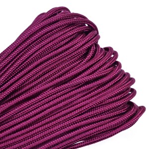 Puede incluir: Primer plano de una cuerda de paracord de color morado oscuro. La cuerda está enrollada apretada y muestra la textura del cordón.
