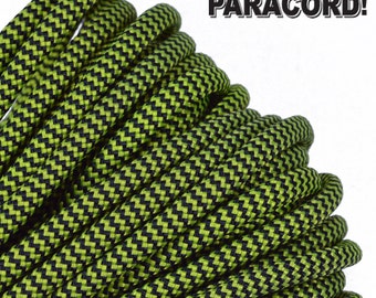 May include: Close-up of a green and black paracord with a chevron pattern. The paracord is coiled and ready to be used for crafting projects.