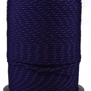 May include: A spool of dark blue paracord with thin red stripes. The paracord is wound tightly around the spool.