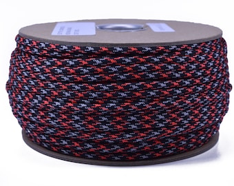 May include: A spool of patterned cord in a houndstooth design. The cord features a repeating pattern of black, red, and gray. The spool is made of cardboard and is suitable for various crafting projects.