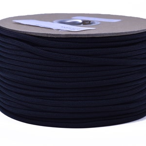 May include: A spool of black paracord, a type of strong nylon rope, is wound tightly on a cardboard tube.