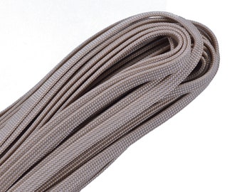 May include: A close-up of a beige paracord rope, a type of strong nylon cord often used for crafting and outdoor activities.