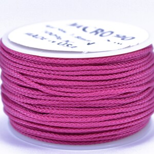 May include: A spool of pink waxed cord, labeled "MICRO" on the white label.