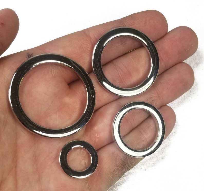 K&ouml;nnte beinhalten: Vier silberne Metallringe in verschiedenen Gr&ouml;&szlig;en. Die Ringe sind glatt und gl&auml;nzend.